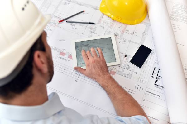 Topkontor-Handwerk Software Anwender Architekt mit Tablet und technischer Zeichnung am Arbeitsplatz